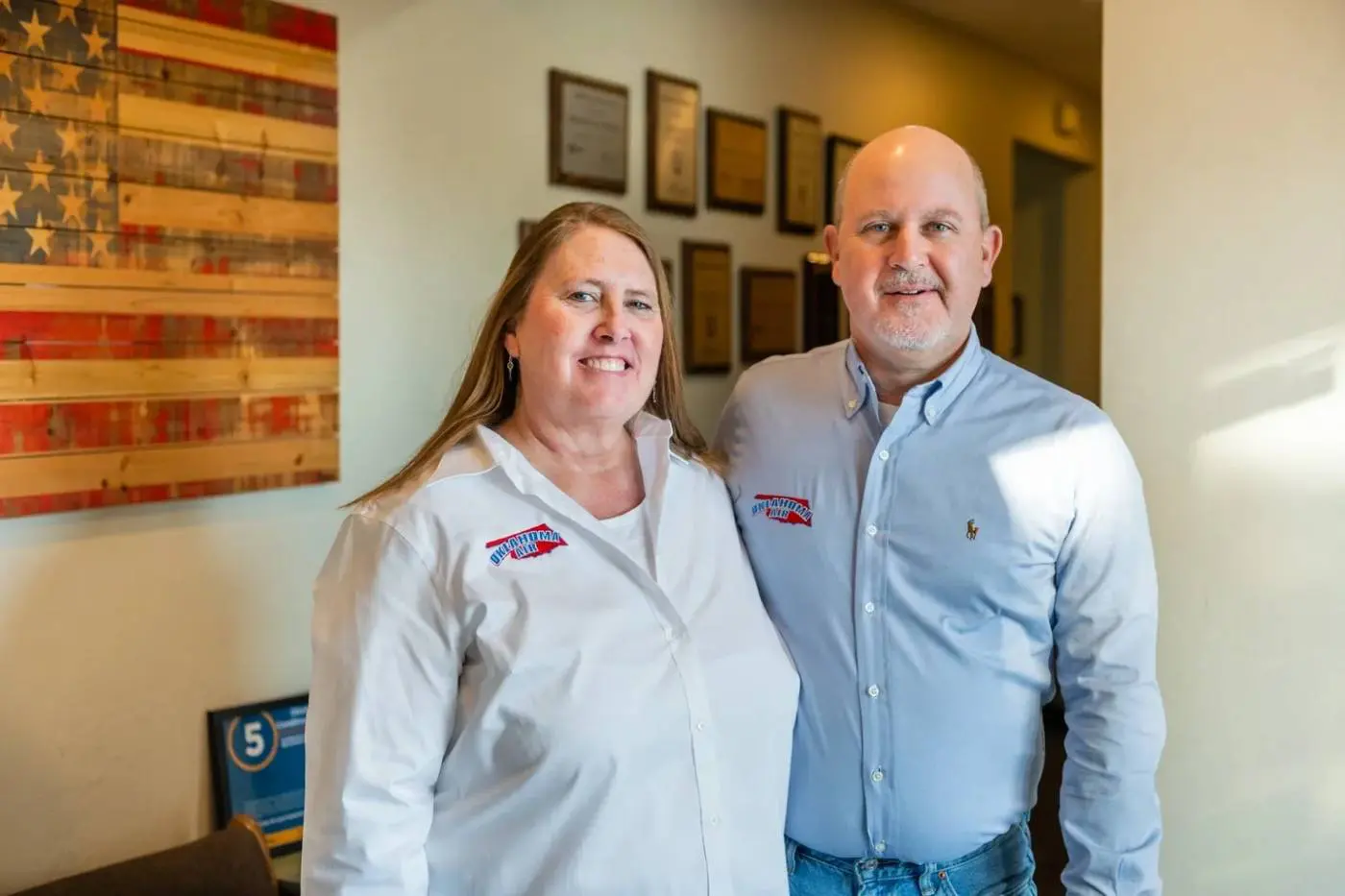 A man and woman standing in front of some pictures.