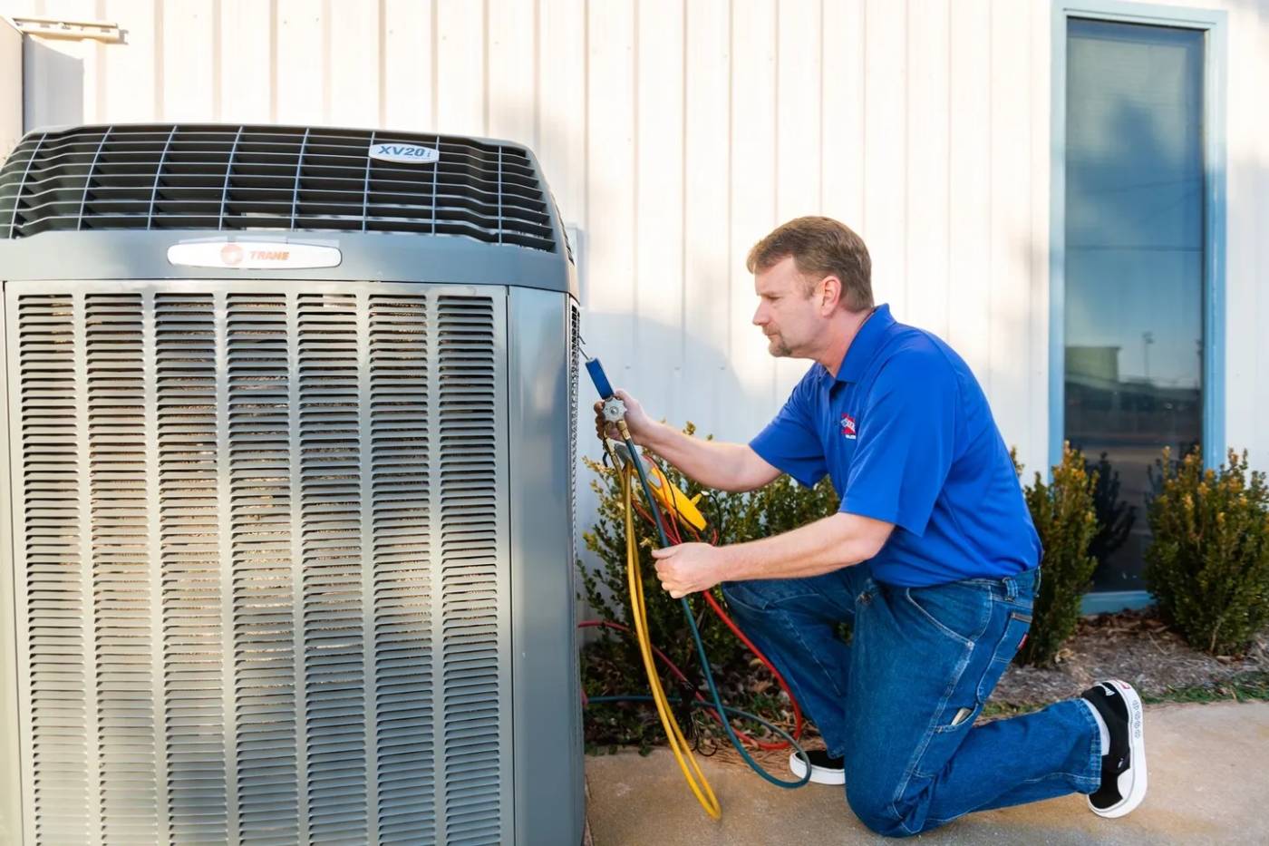 A man working on an air conditioner unit.